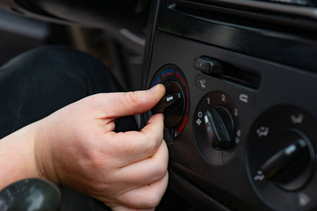 Close-up of a male hand adjusting the air conditioning in a car