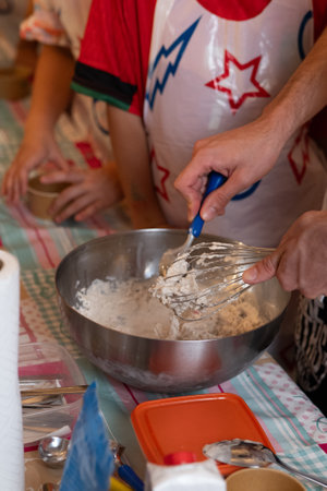 Close-up of a woman's hands kneading dough with a whiskの写真素材