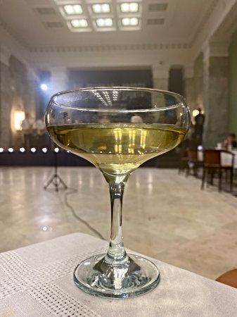 White wine in a glass on the table in the interior of the restaurantの写真素材