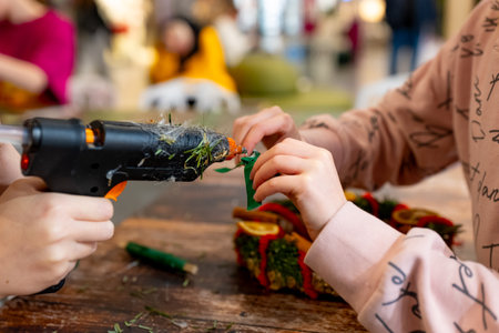 Close-up of hands of a little girl decorating a Christmas tree