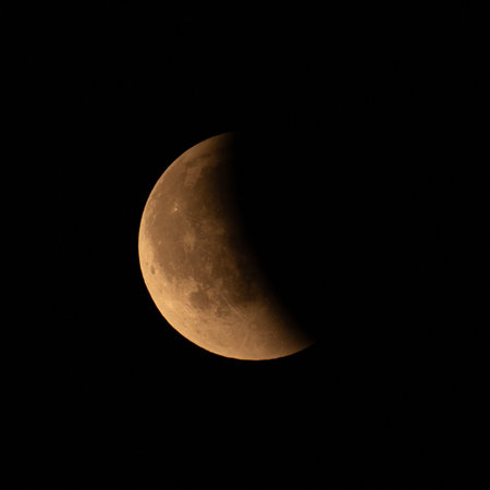 Half moon in the night sky. Close-up of a lunar eclipse.