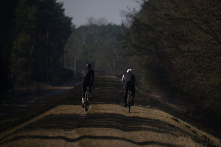 cycling in the countryside in the evening, silhouette of two cyclistsの写真素材