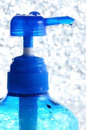 a blue bottle of shampoo with pump on ice look backgroundの写真素材