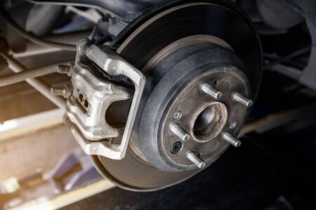 modern car disc brake to be fixed at garage or automotive service station with sunlight effect, shallow depth of fieldの写真素材
