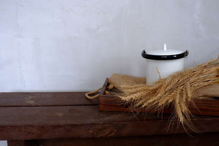 Composition of various rustic items on the background of a gray wall. Wheat ears in a tray along...