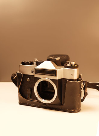 An old camera. Sepia. Light table, brown background. Retro equipment