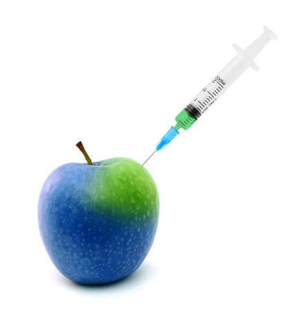 Syringe stuck in an apple isolated over white backgroundの写真素材