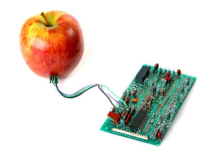 Red apple connected to the electric board isolated over white backgroundのeditorial素材