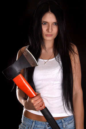 Young woman with a big axe over black background