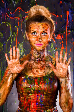 Beautiful young woman covered with multicolored paintsの写真素材