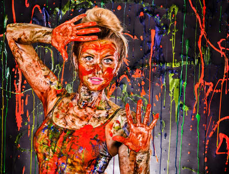 Beautiful young woman covered with multicolored paints