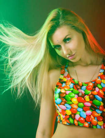 Gorgeous young woman in a cloud of smoke between red and green lightsの写真素材