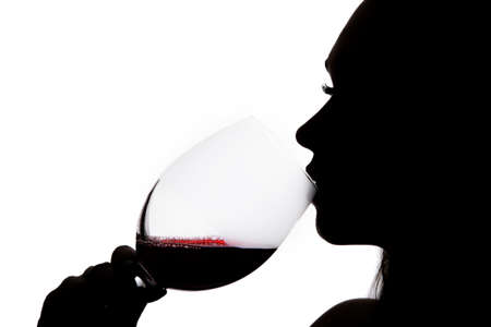 Silhouette of a woman drinking the wineの写真素材