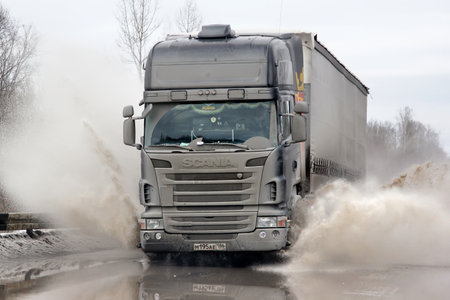 ASHA, RUSSIA - MARCH 15, 2015: Black semi-trailer truck Scania R420 at the city street during a strong flood.のeditorial素材