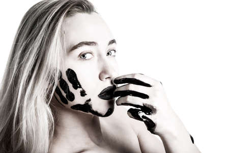 Young woman with a tarred hands and a faceの写真素材