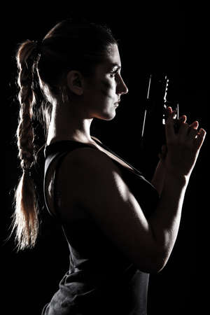 Military woman with a gun over black backgroundの写真素材