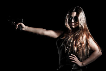 Military woman with a gun over black backgroundの写真素材