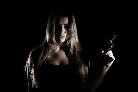 Military woman with a gun over black backgroundの写真素材