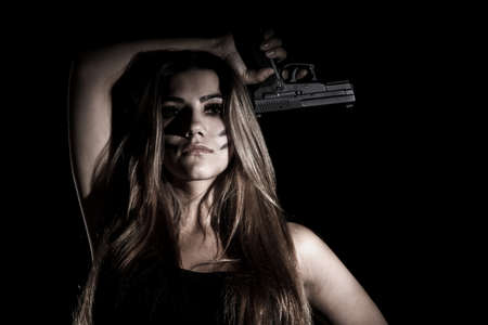 Military woman with a gun over black backgroundの写真素材