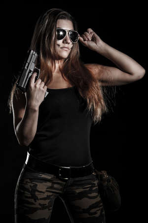 Military woman with a gun over black backgroundの写真素材