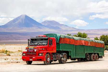 SAN PEDRO DE ATACAMA, CHILE - NOVEMBER 15, 2015: Semi-trailer truck Scania T at the background of a volcano.のeditorial素材