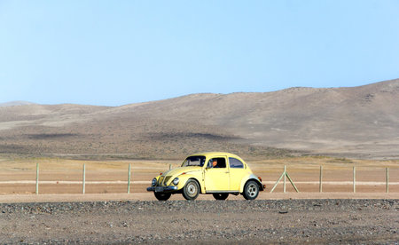 ATACAMA, CHILE - NOVEMBER 18, 2015: Retro motor car Volkswagen Beetle moves at the Pan-American Highway through the Atacama desert.のeditorial素材