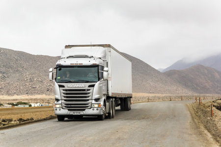 ATACAMA, CHILE - NOVEMBER 14, 2015: Semi-trailer truck Scania R400 at the gravel interurban freeway through the Atacama desert.のeditorial素材