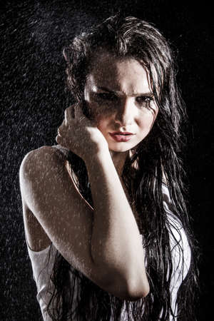 Wet sexy woman covered with water drops over black backgroundの写真素材