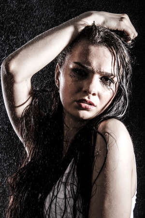 Wet sexy woman covered with water drops over black backgroundの写真素材