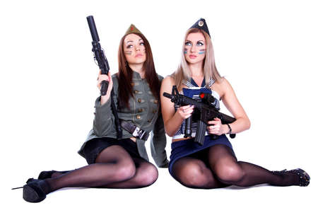 Two women in the military uniform with guns isolated over white backgroundの写真素材