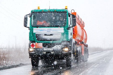 NOVYY URENGOY, RUSSIA - APRIL 28, 2013: Cistern semi-trailer truck MAN TGS at the interurban road during a heavy blizzard.のeditorial素材