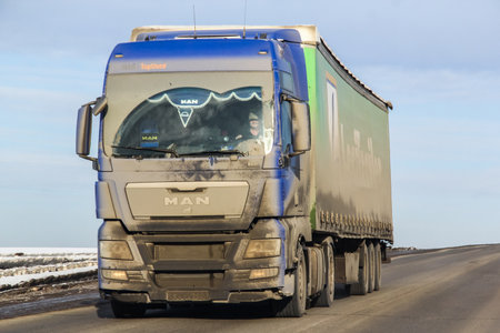 BASHKORTOSTAN, RUSSIA - MARCH 11, 2015: Dirty semi-trailer truck MAN TGX at the interurban freeway.のeditorial素材