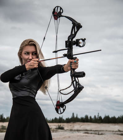Young woman with a compound bowの写真素材