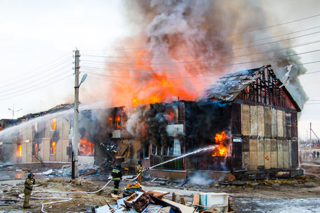 NOVYY URENGOY, RUSSIA - MAY 14, 2015: Old wooden residential house burns with black smoke and heavy flames.のeditorial素材