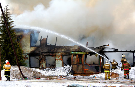 NOVYY URENGOY, RUSSIA - MAY 9, 2015: Old wooden residential house burns with a grey smoke and heavy flames.のeditorial素材