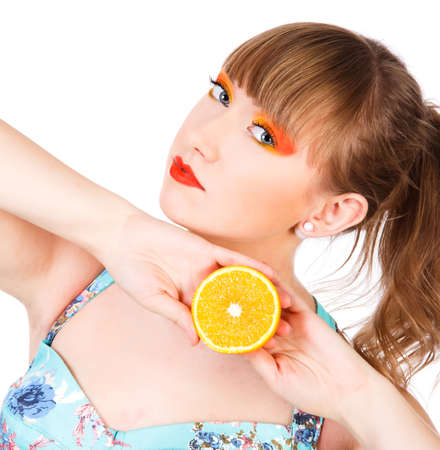 Cute young woman with an orange fruit isolated over white backgroundの写真素材