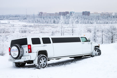 NOVYY URENGOY, RUSSIA - OCTOBER 21, 2016: White limousine Hummer H3 in the snow covered forest.のeditorial素材