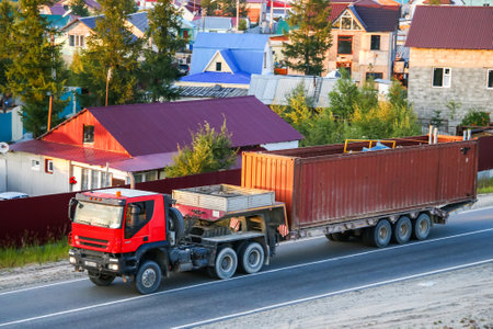 NOVYY URENGOY, RUSSIA - AUGUST 13, 2016: Red semi-trailer truck Iveco Trakker in the city street.のeditorial素材