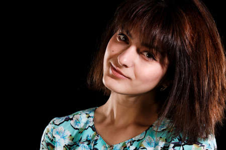 Studio portrait of a young pretty girl over black backgroundの写真素材