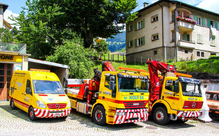 VALAIS, SWITZERLAND - AUGUST 5, 2014: Road service trucks of the Wolfi SA company in the village street.のeditorial素材