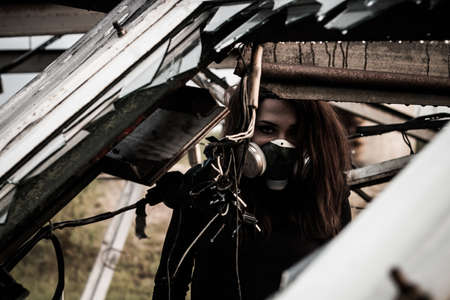 Woman in the gas mask inside the rusty structureの写真素材