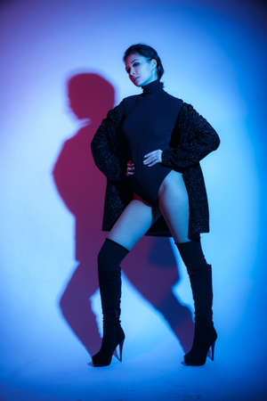 Fashion portrait of a beautiful young woman in red and blue lightsの写真素材