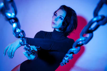Fashion portrait of a beautiful young woman in red and blue lights