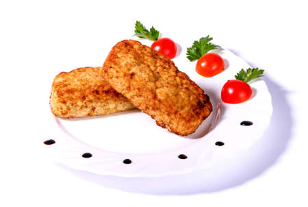Two cutlets with cherry tomatoes and parsley isolated over white backgroundの写真素材