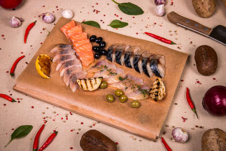 Herring fillet at the background of the chilli pepper, cashew nuts and green leavesの写真素材