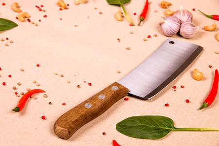 Wooden knife on the table with the chilli pepper, cashew nuts and green leavesの写真素材