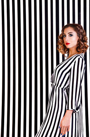 Pretty young girl at the background of black and white vertical stripesの写真素材