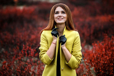 Happy young woman in the red bushesの写真素材