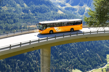 Saint Gotthard Pass, Switzerland - September 13, 2019: Yellow suburban coach bus Setra S415H at the high mountain Alpine road.のeditorial素材