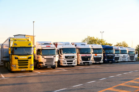 Piedmont, Italy - September 12, 2019: Semi-trailer trucks at the interurban road at the background of a sunset.のeditorial素材